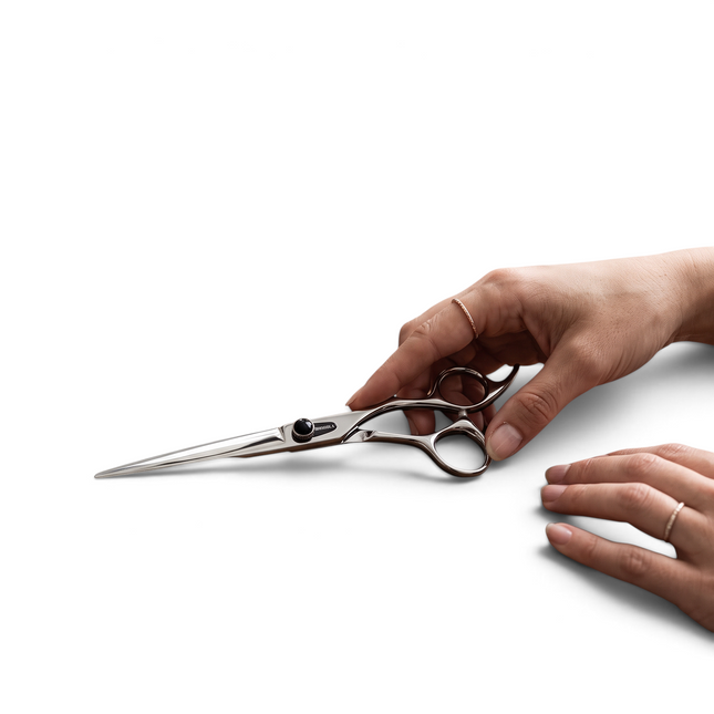 Razor Sharp AZ Dynasty Renegade lefty barber shear with silver finish and offset camelback handle held by a hand