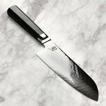 Razor Sharp AZ Shun Dual Core 7-inch Santoku knife featuring a herringbone pattern blade and black PakkaWood handle.
