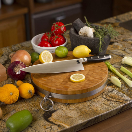 Razor Sharp AZ Dragon by Apogee 10-inch chef's knife with satin finish blade and black micarta handle on wood board