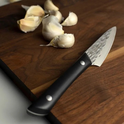Razor Sharp AZ 3.5-inch paring knife with a hammered stainless steel blade and black riveted handle on a wood board.