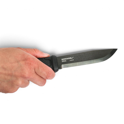 Hand holding a black Morakniv Garberg carbon steel bushcraft knife with a DLC coated blade and textured grip.
