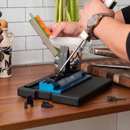 Razor Sharp AZ Wicked Edge GO WE60 knife sharpener with blue base and diamond stones in use on a kitchen counter