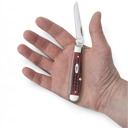 Razor Sharp AZ Case Pocket Worn Mini Trapper knife with red bone corn cob jigged handle held in a person's palm.