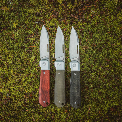 Razor Sharp AZ Case Highbanks pocket knives with rosewood, OD green, and black Micarta handles on mossy ground