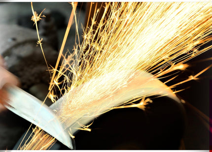 Razor Sharp AZ blade sharpening service with bright sparks flying from a knife being sharpened.