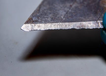 Razor Sharp AZ blade sharpening service shows a close-up of a dull, serrated utility knife blade.