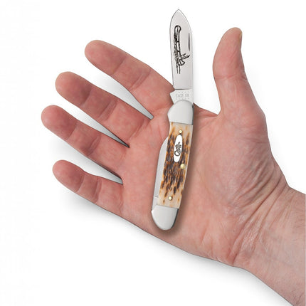 Razor Sharp AZ Case Amber Jigged Bone Canoe pocket knife with Indian in canoe etching held in an open palm