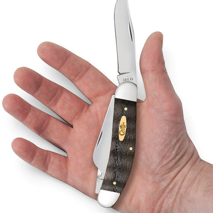 Razor Sharp AZ Case Sowbelly pocket knife with black curly oak wood handle held in a palm for scale