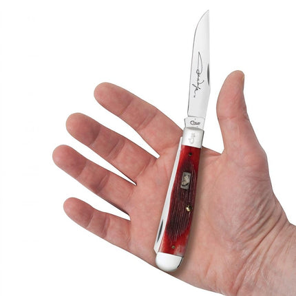Razor Sharp AZ Case John Wayne Trapper knife with barnboard jig dark red bone handle held in a hand