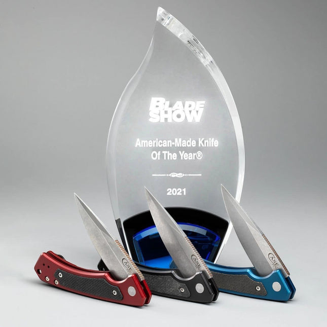Razor Sharp AZ Case Marilla folding knives in red, black, and blue with G-10 inlays displayed before a Blade Show award.