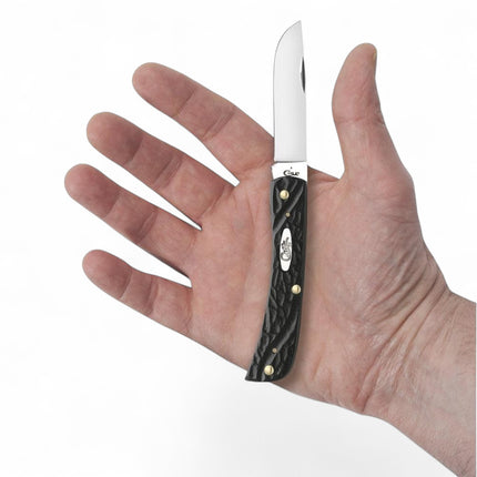 Razor Sharp AZ Case Jigged Rough Black Synthetic Sod Buster Jr pocket knife with clip-point blade held in a hand.