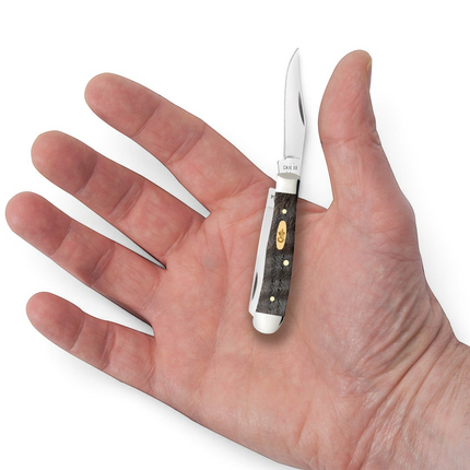 Razor Sharp AZ Case Tiny Trapper pocket knife with black curly oak wood handle held in an open palm