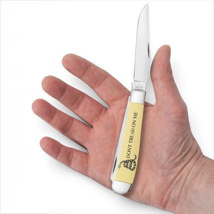 Razor Sharp AZ Case Trapper knife with a yellow synthetic handle featuring Dont Tread on Me embellishment in a hand