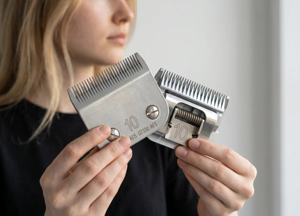 Razor Sharp AZ professional clipper blade sharpening service. Close-up of two silver metal clipper blades held by a woman.