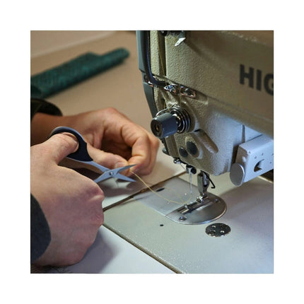 Razor Sharp AZ KAI 7100 professional 4-inch scissors with elastomer handles snipping thread at a sewing machine