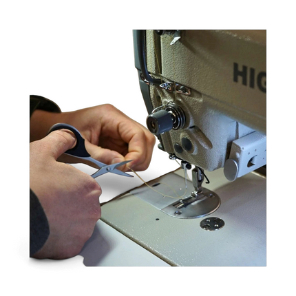 Razor Sharp AZ KAI 7100 professional 4-inch scissors with elastomer handles snipping thread at a sewing machine