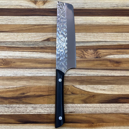 Razor Sharp AZ Kai Pro 6" Nakiri knife with hammered stainless steel blade and black POM handle on a wooden cutting board.