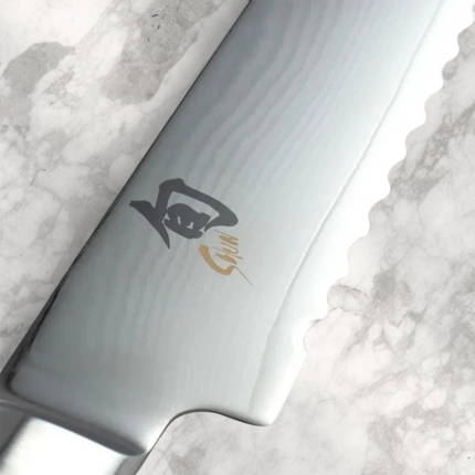 Razor Sharp AZ Shun Classic 9-inch bread knife featuring a serrated Damascus steel blade with a detailed logo.