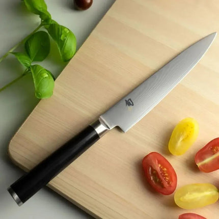 Razor Sharp AZ Shun Classic 6-inch utility knife with Damascus steel blade and black PakkaWood handle on wood board