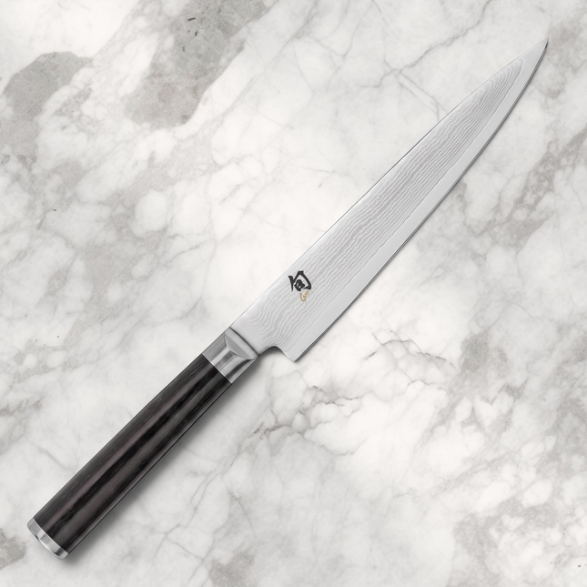 Razor Sharp AZ Shun Classic 6-inch utility knife featuring a Damascus steel blade and a black D-shaped PakkaWood handle.