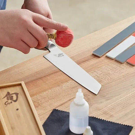 Razor Sharp AZ Shun Knife Care Kit: person cleaning knife with talc ball, polishing sticks, oil, and cloths