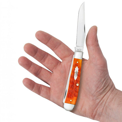 Razor Sharp AZ Case Crandall Tequila Sunrise bone trapper pocket knife with orange jigged handle held in hand