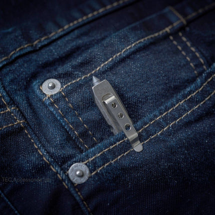 Razor Sharp AZ Ti-Pry titanium pocket tool with integrated clip secured in a dark blue denim jeans pocket