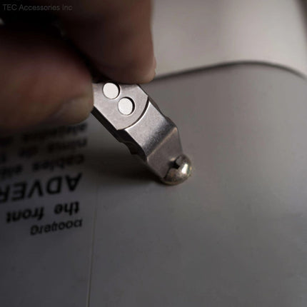 Razor Sharp AZ Ti-Pry titanium pocket pry bar being used to scrape a surface with its durable metal tip